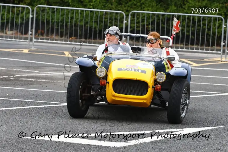 Classic open sports car crew in goggles at a targa rally