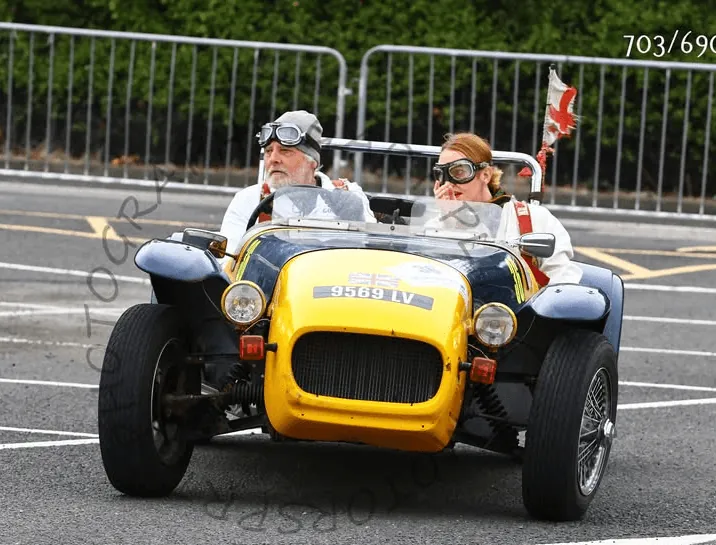 Classic open sports car with driver and passenger in goggles