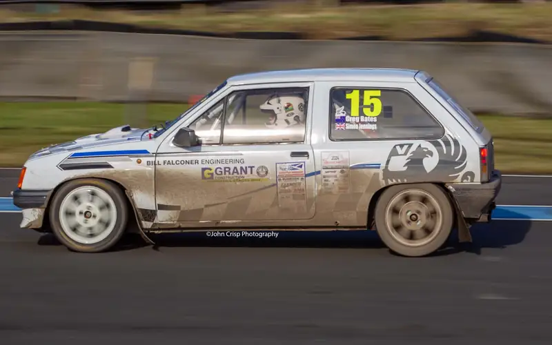 Silver hatchback rally car at speed