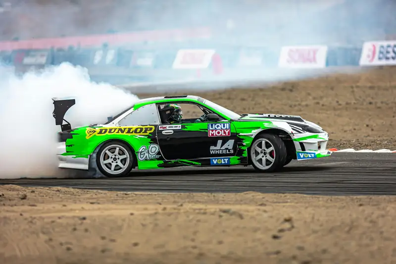 Green drift car in tyre smoke
