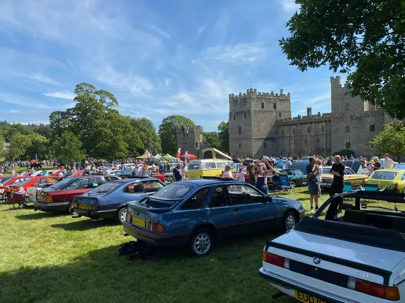 Classic cars on display in front of a castle